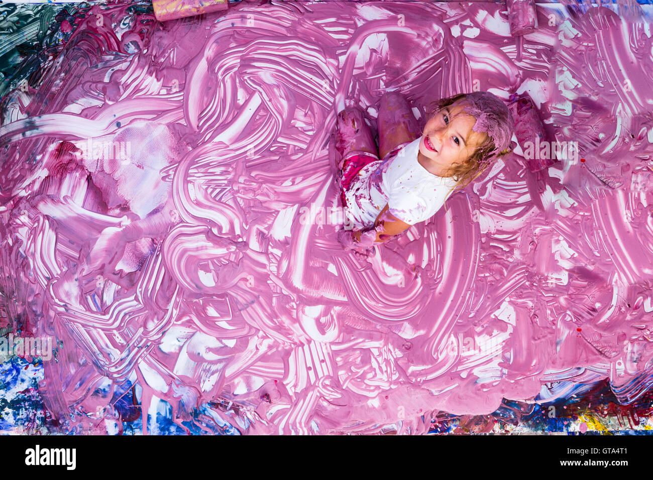 Joyful five year old girl playing in paint Stock Photo