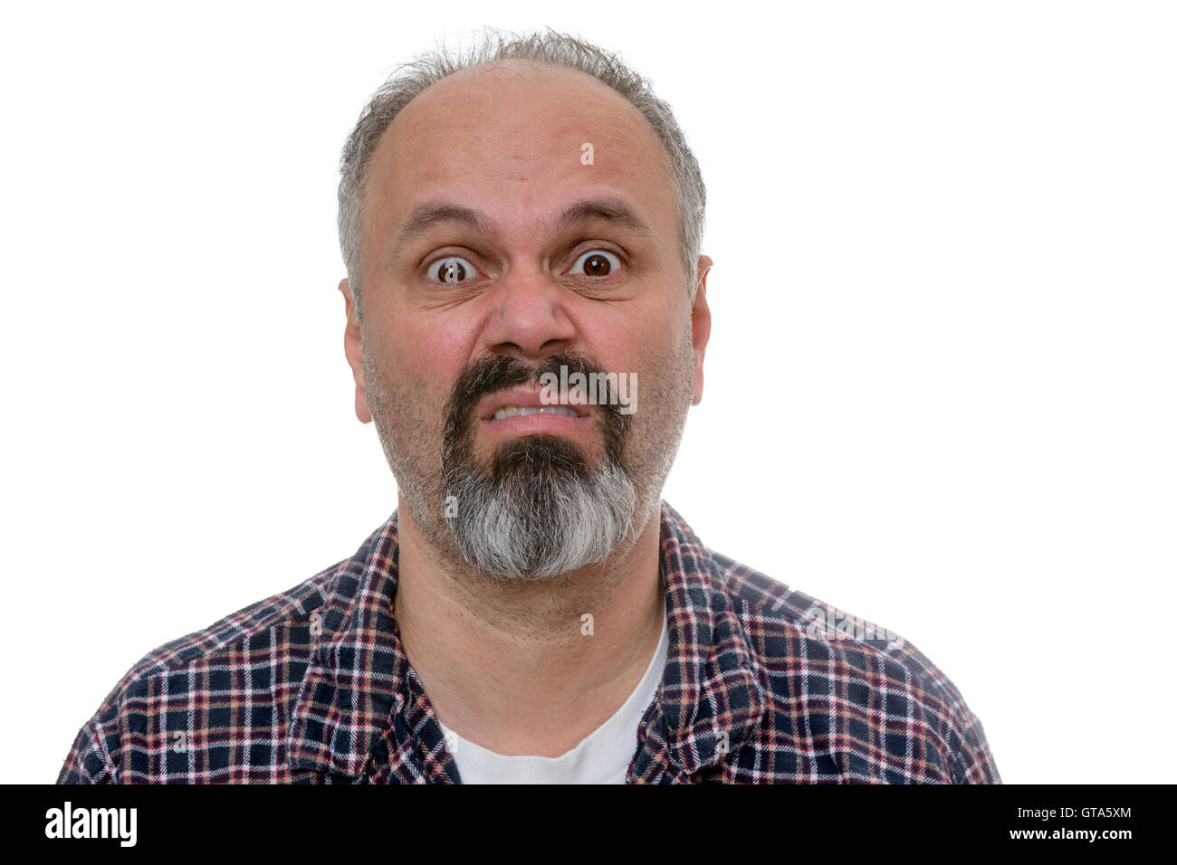 Middle-age man with a goatee with Monday morning blues standing in his pyjamas pulling a wide eyed disgruntled face of mock horr Stock Photo
