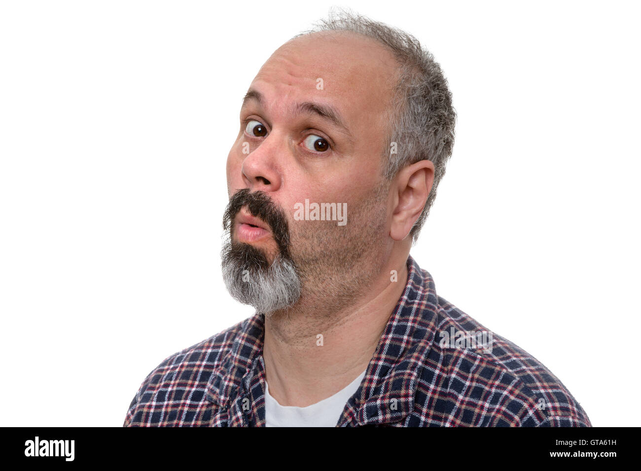 Surprised middle-aged man in his pyjamas in the early morning looking sideways at the camera with an expression of incredulous a Stock Photo