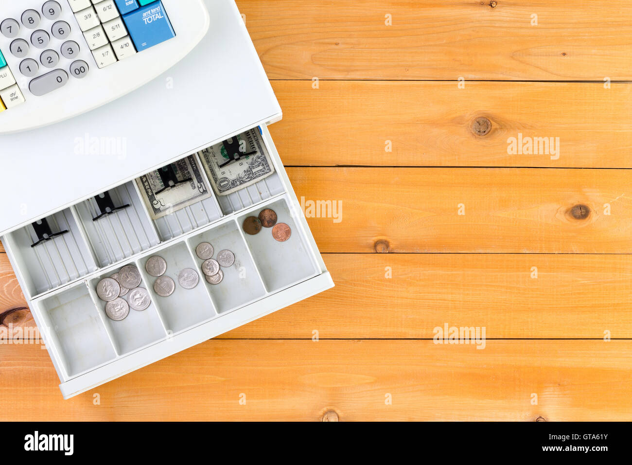 Nearly empty cash register drawer on table from top down view with copy space on wooden table Stock Photo