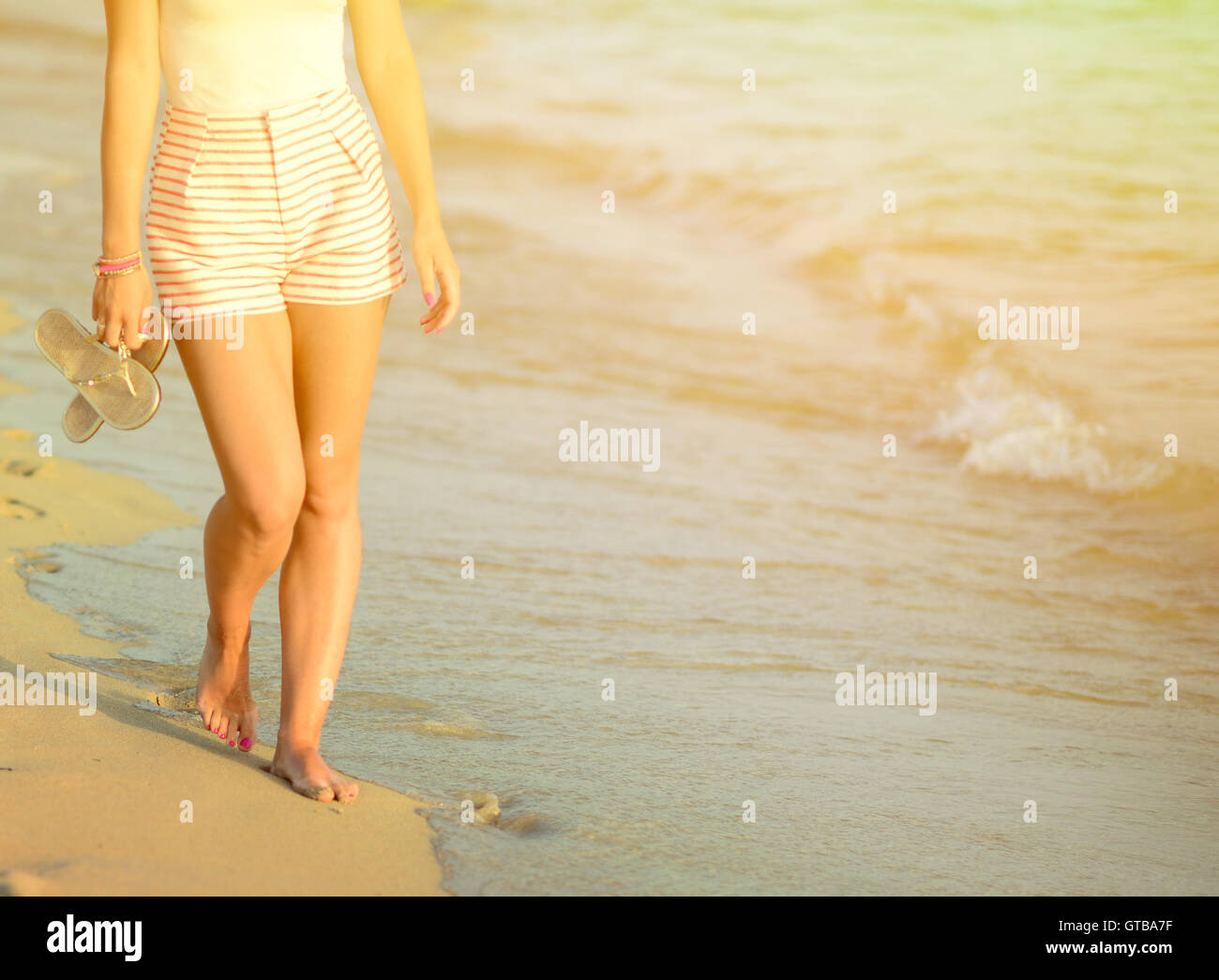 Beach travel - woman walking on sand beach leaving footprints in the ...