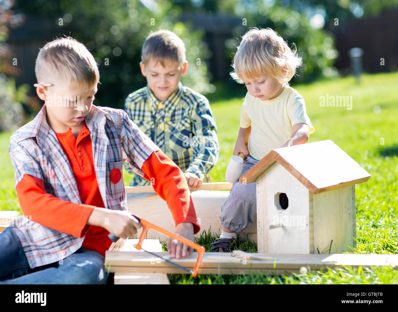 Happy kids brothers making wooden birdhouse by hands Stock Photo