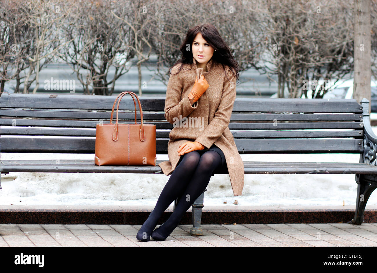 The beautiful young city woman sits on a bench Stock Photo - Alamy