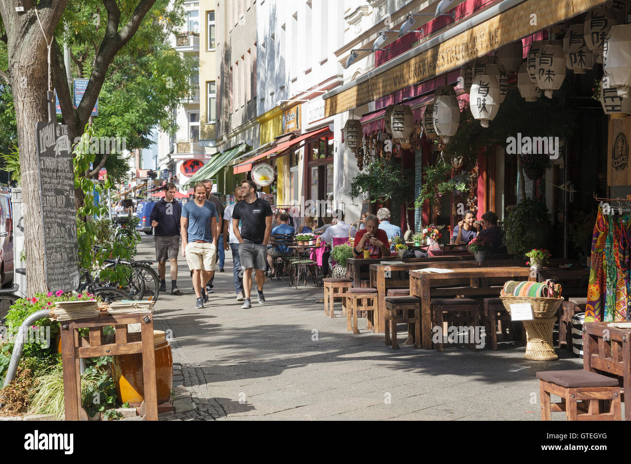 Bergmannstrasse in Kreuzberg people walking and sitting outside Umami Restaurant, Berlin, Germany Stock Photo