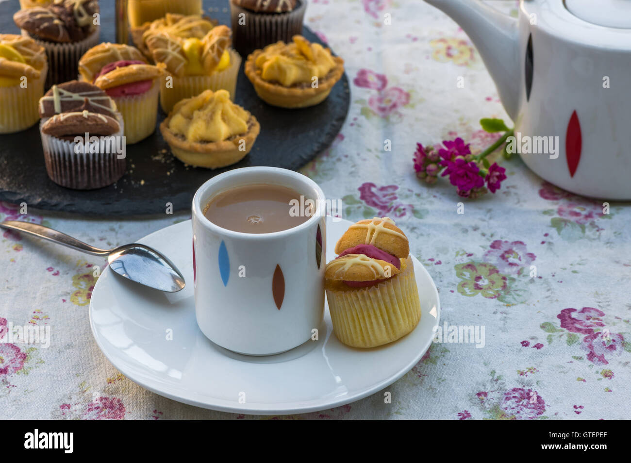 Tea with cakes and macaroons set up on the table in the garden Stock Photo