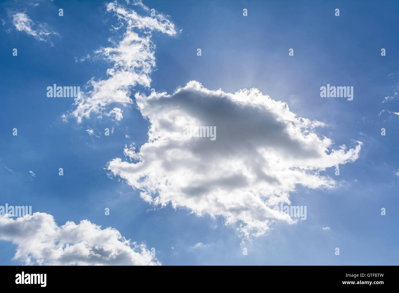 Sun hiding beyond the clouds on a bright summers day. Stock Photo