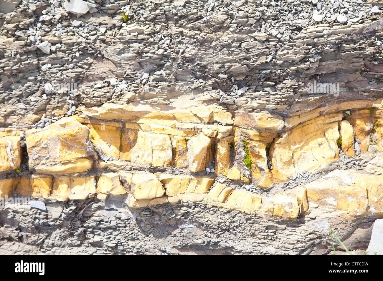 Details of yellow stone layer in grey stone mountain Stock Photo