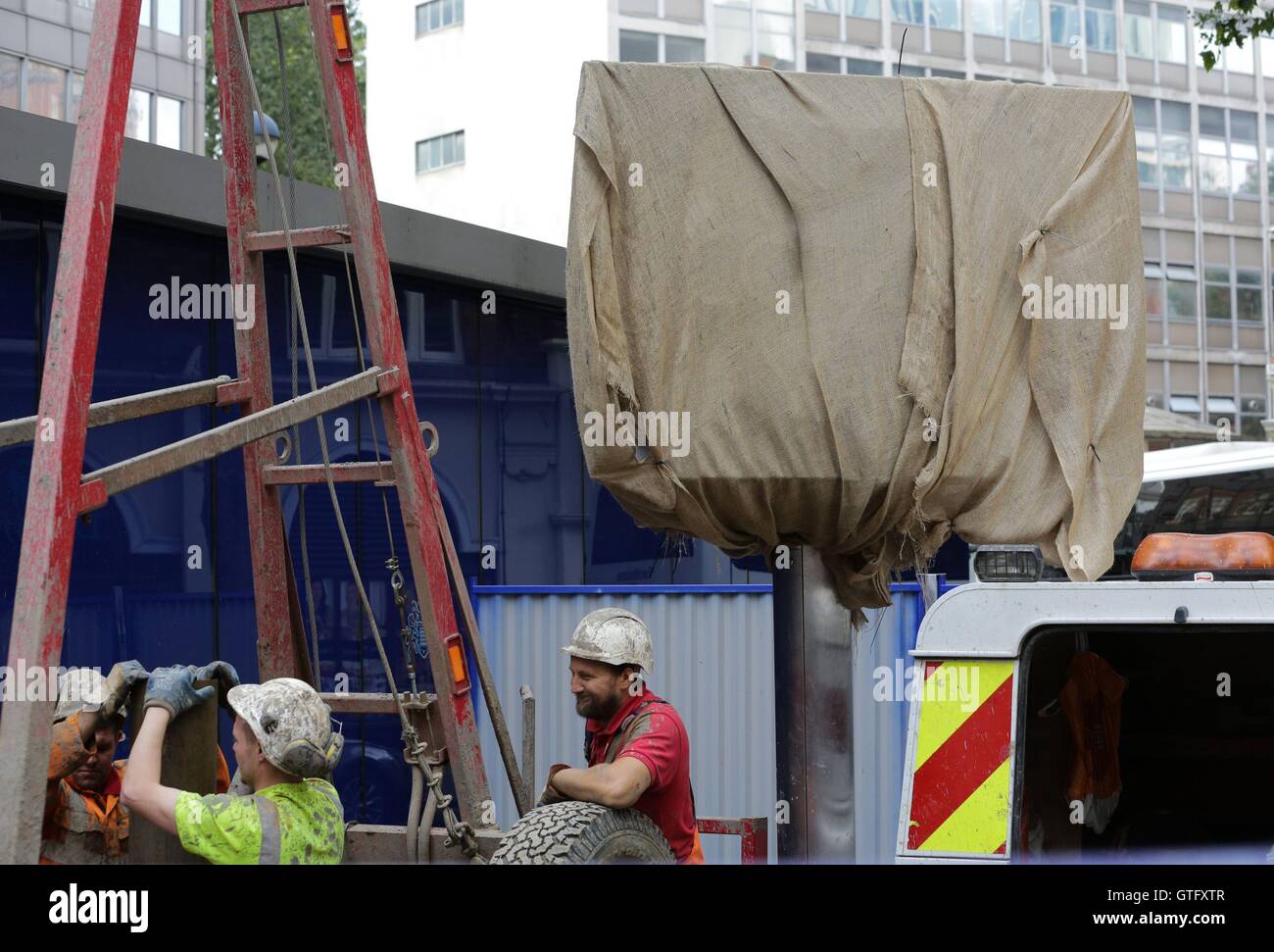 The iconic revolving sign in front of the New Scotland Yard headquarters of the Metropolitan Police in central London is wrapped in a sheet as workers make preparations to move it to the force's new base at the Curtis Green building on Victoria Embankment. Stock Photo