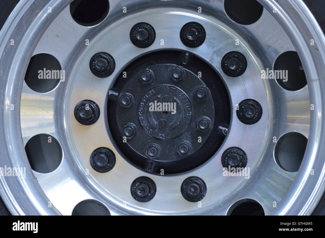 A school bus wheel shows symmetry and pattern. Stock Photo