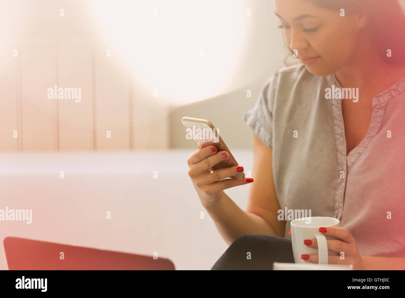 Businesswoman drinking coffee texting with cell phone Stock Photo