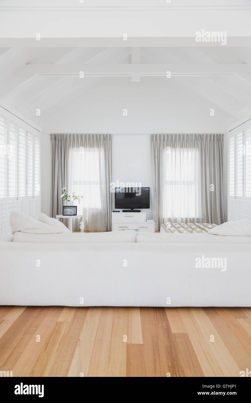 White living room with vaulted wood beam ceiling in home showcase interior Stock Photo