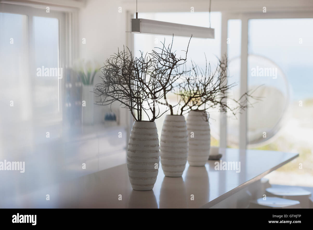 Modern white vases with branches on kitchen island Stock Photo Alamy