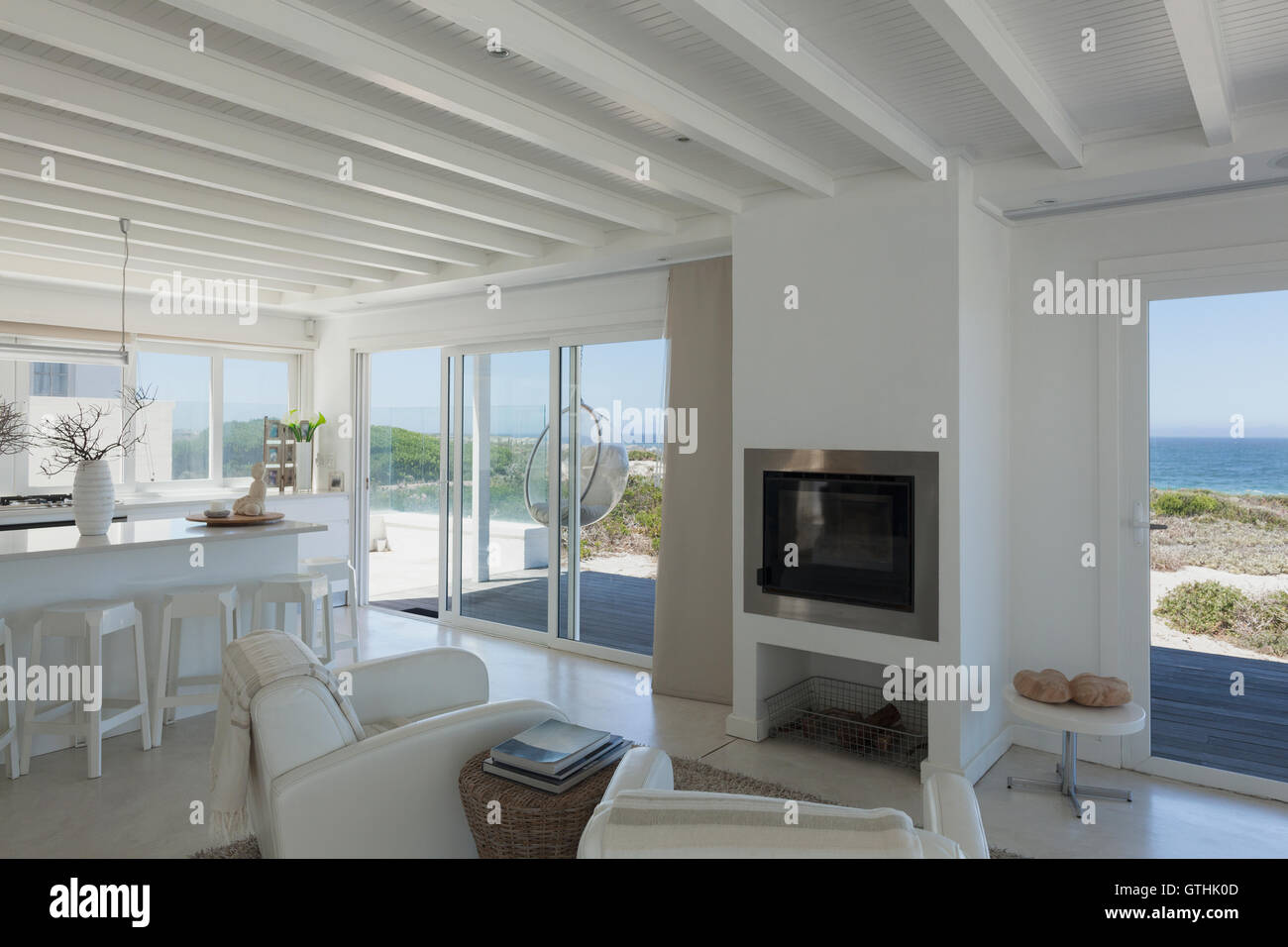 Open floor plan with wood beam ceiling and ocean view Stock Photo