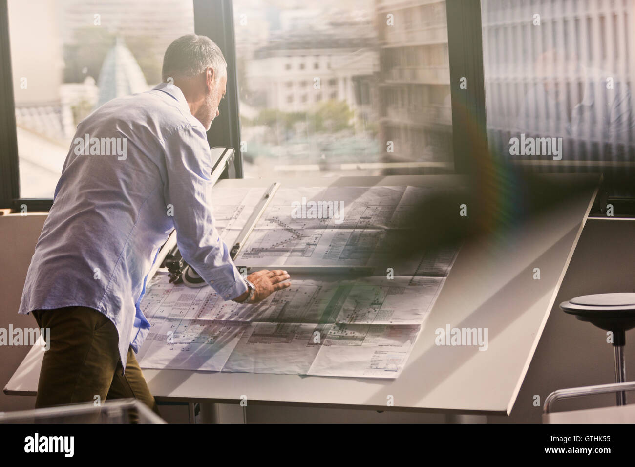 Architect reviewing blueprints in office Stock Photo Alamy