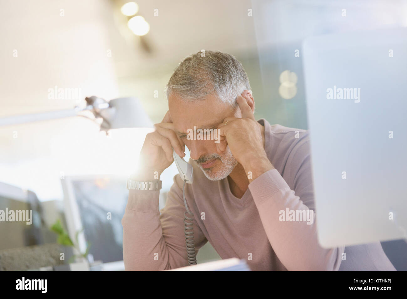 Serious businessman talking on telephone in office Stock Photo