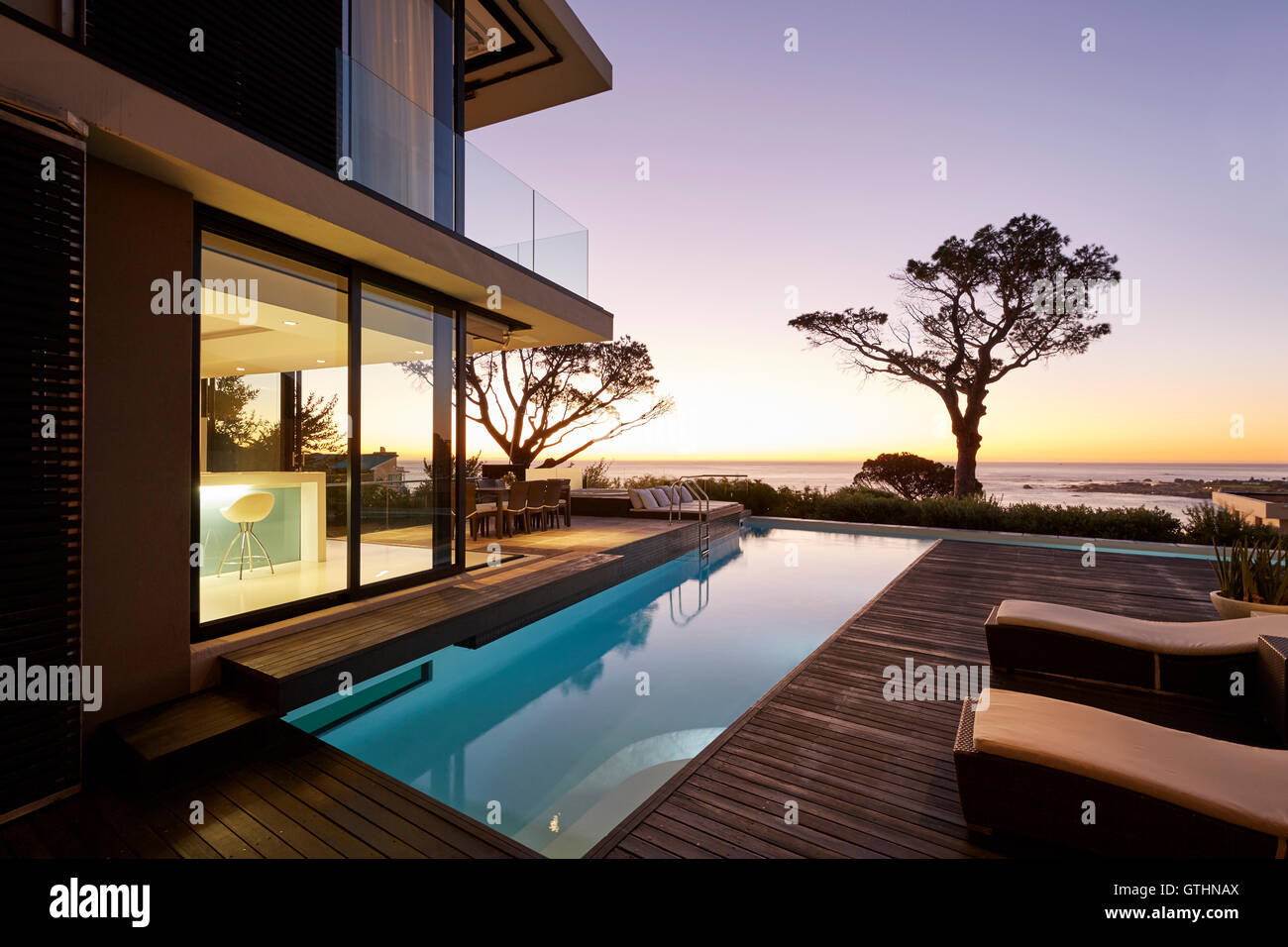 Modern luxury home showcase patio and swimming pool with sunset ocean ...