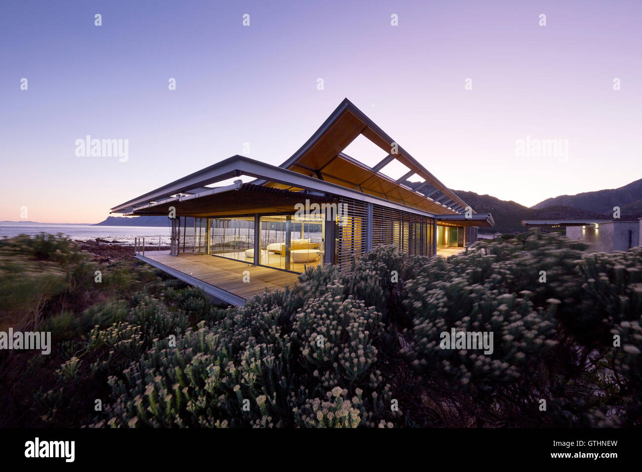Modern luxury house with ocean view at dusk Stock Photo - Alamy