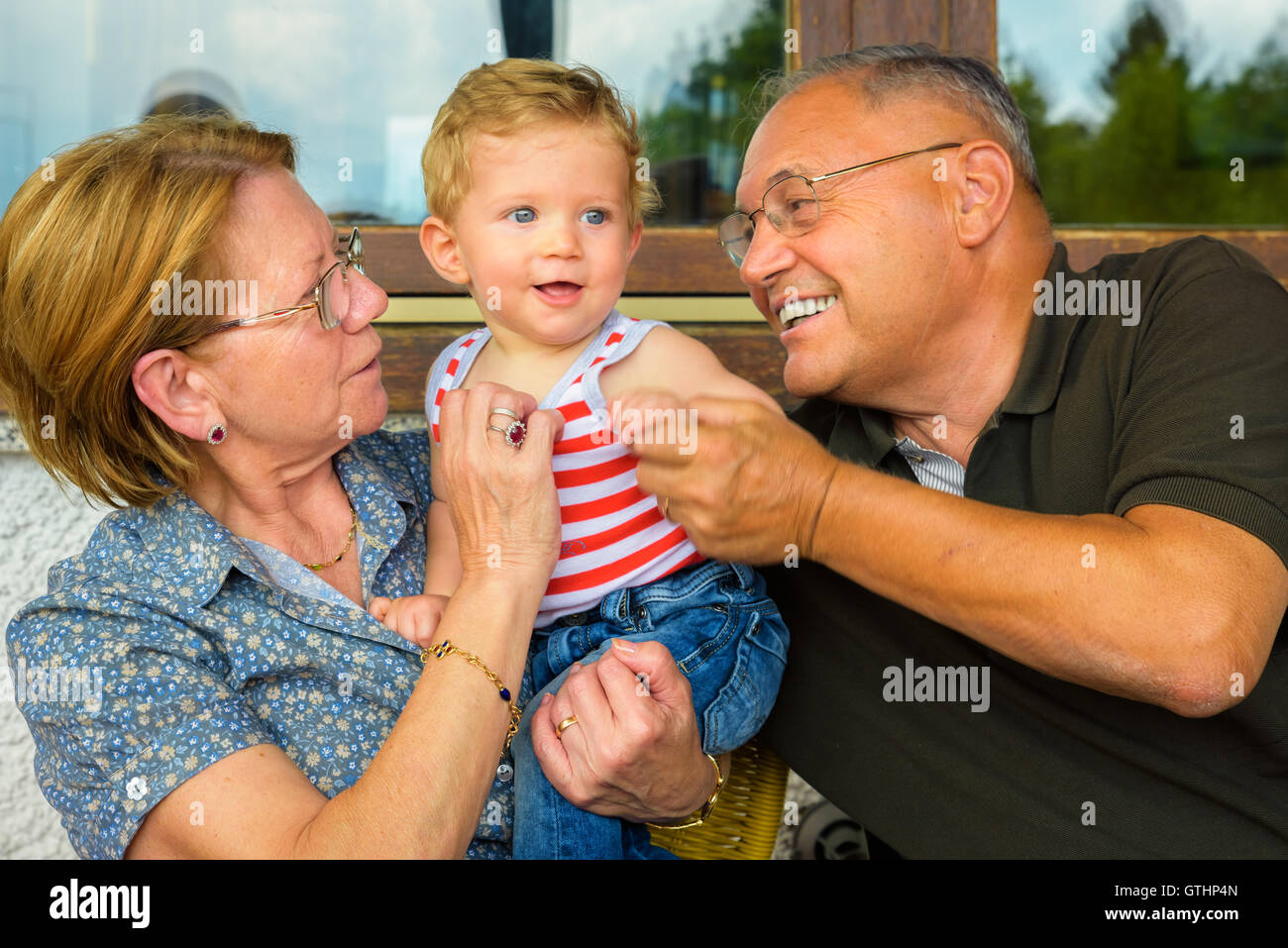Family moment,Grandparents having great fun with their grandchild. Stock Photo