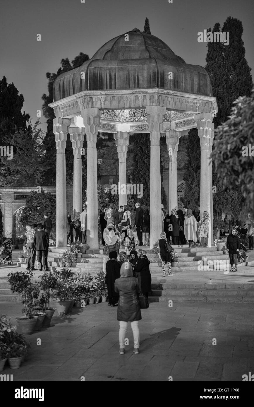 The Tomb of Hafez and its associated memorial hall, the Hāfezieh, are two memorial structures erected in the northern edge of Shiraz, Iran, in memory of the celebrated Persian poet Hafez. The open pavilion structures are situated in the Musalla Gardens on the north bank of a seasonal river and house the marble tomb of Hafez. The present buildings, built in 1935 and designed by the French architect and archaeologist André Godard, are at the site of previous structures, the best-known of which was built in 1773. Monochrome. Stock Photo
