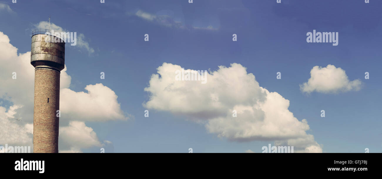 water tower against the backdrop of blue sky with clouds Stock Photo