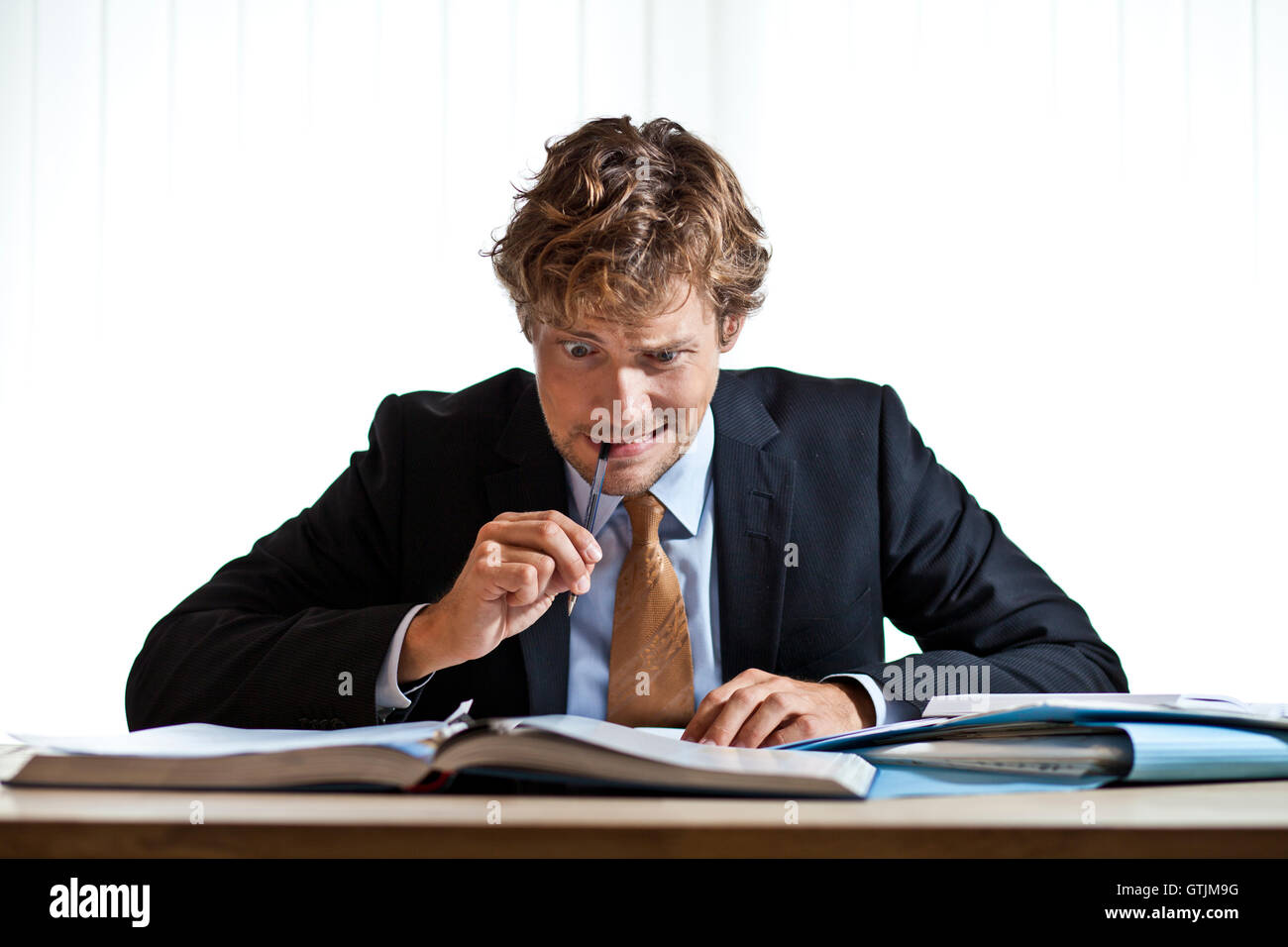 Perplexed businessman working on problem Stock Photo - Alamy