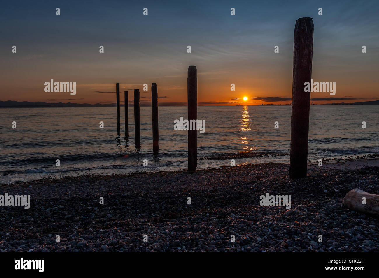 silhouettes of remnants of an early 1900's pier at sunset in Point