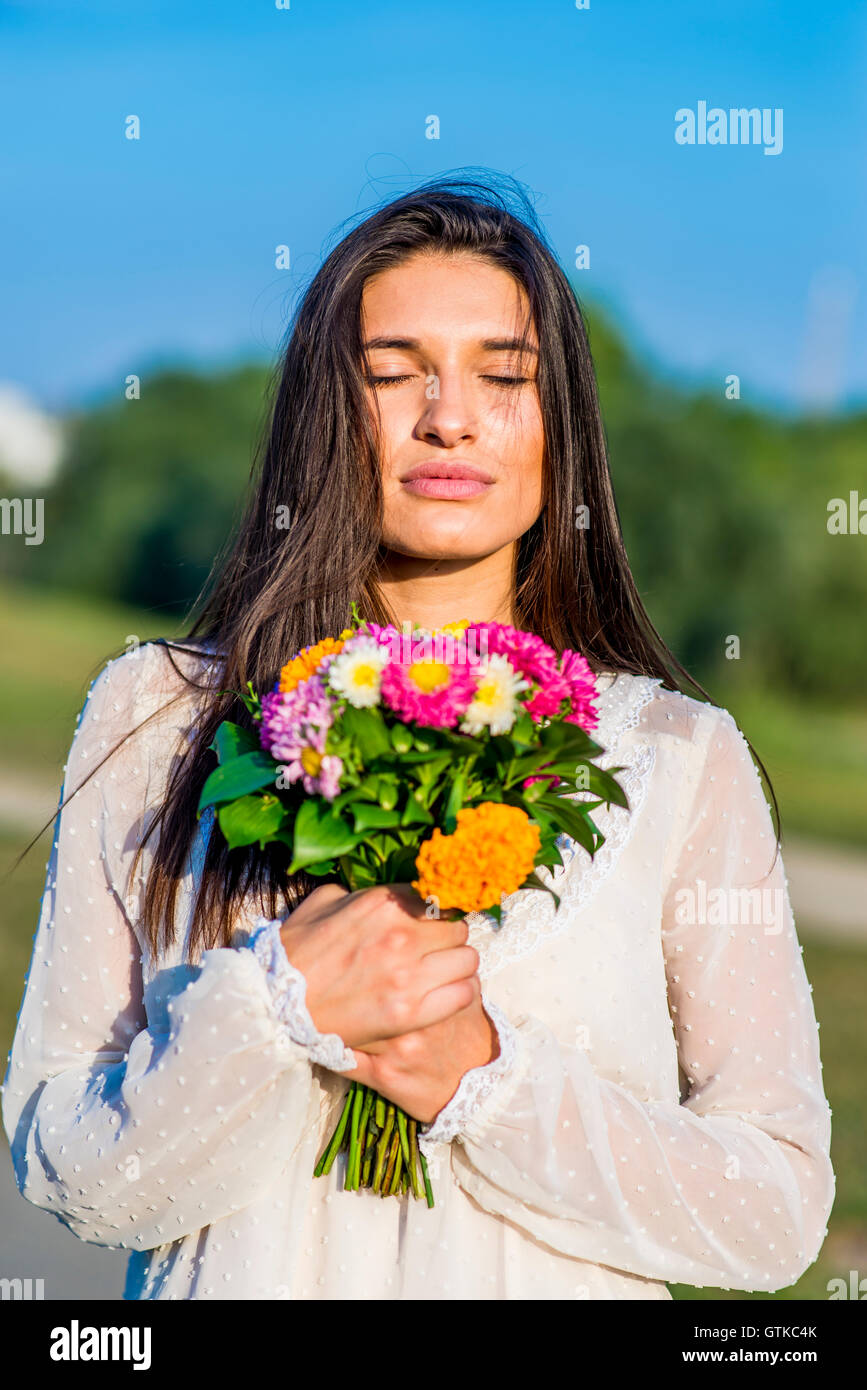 Young women posing outdoors with a bouquet of colorful flowers Stock ...