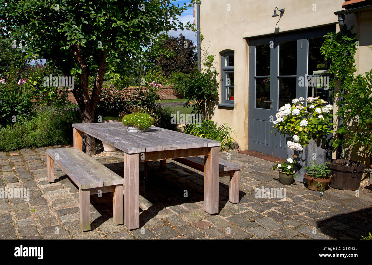 Outdoor garden dining wooden table and benches, English garden,England Stock Photo