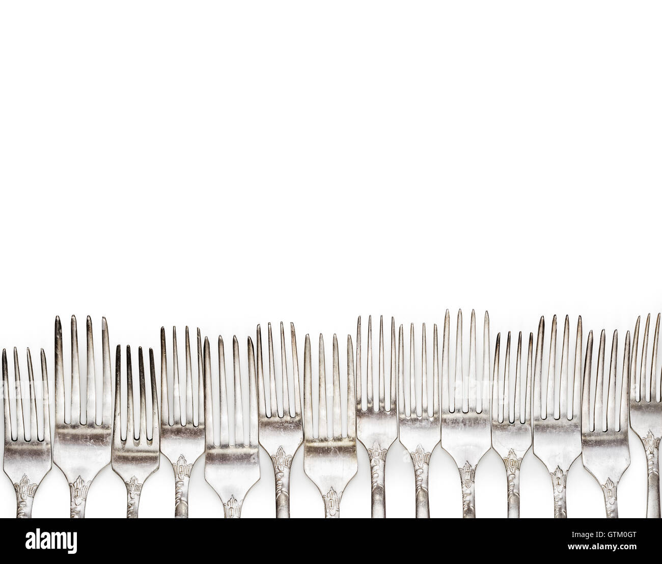 Aged vintage silver forks border isolated on white background. Fork