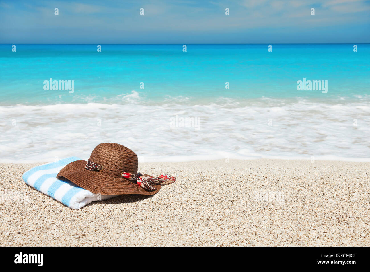 Hat and towel on a beach Stock Photo - Alamy