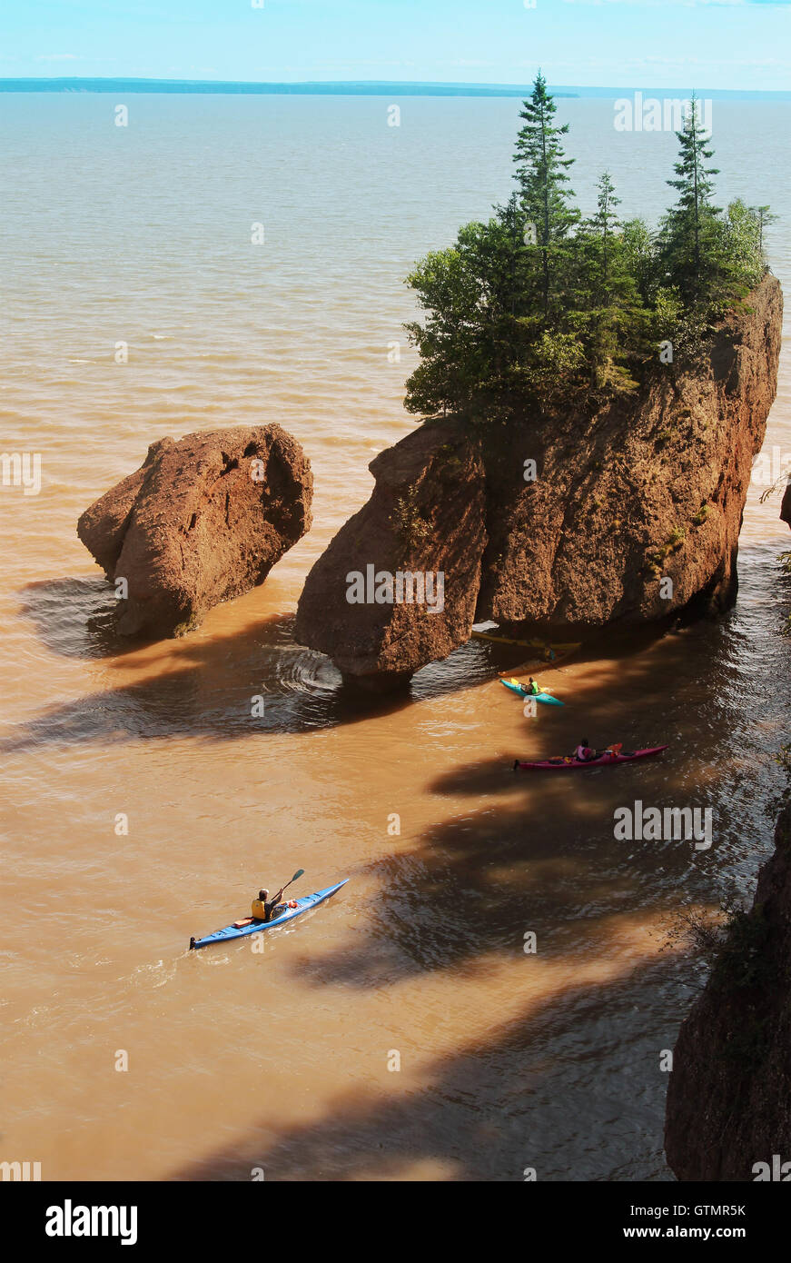 Kayakers at Hopewell Rocks in the Bay of Fundy, New Brunswick, Canada in the muddy water at high tide Stock Photo