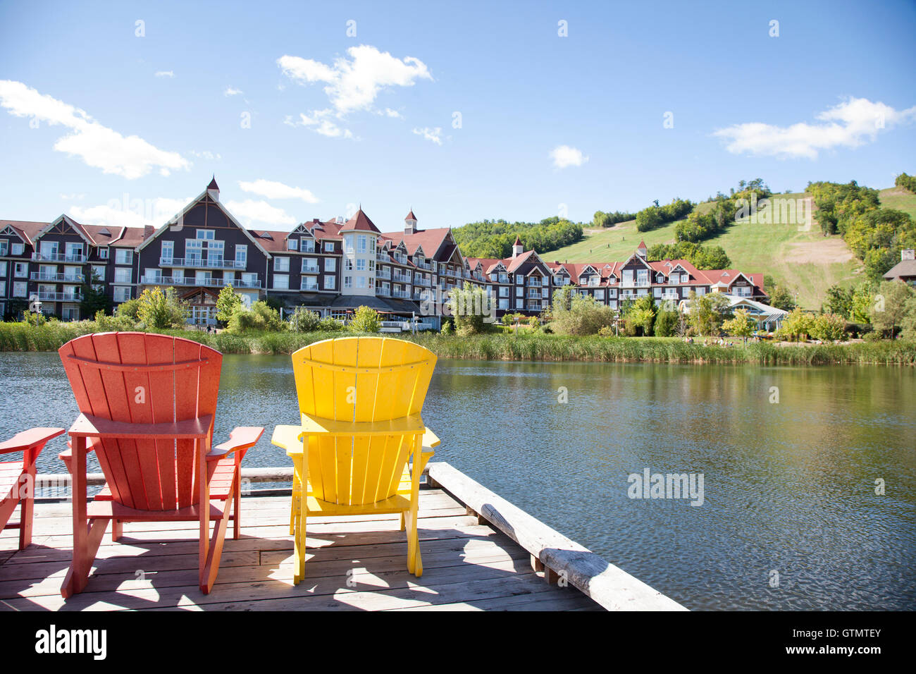 muskoka chairs on a pier by the water Stock Photo Alamy