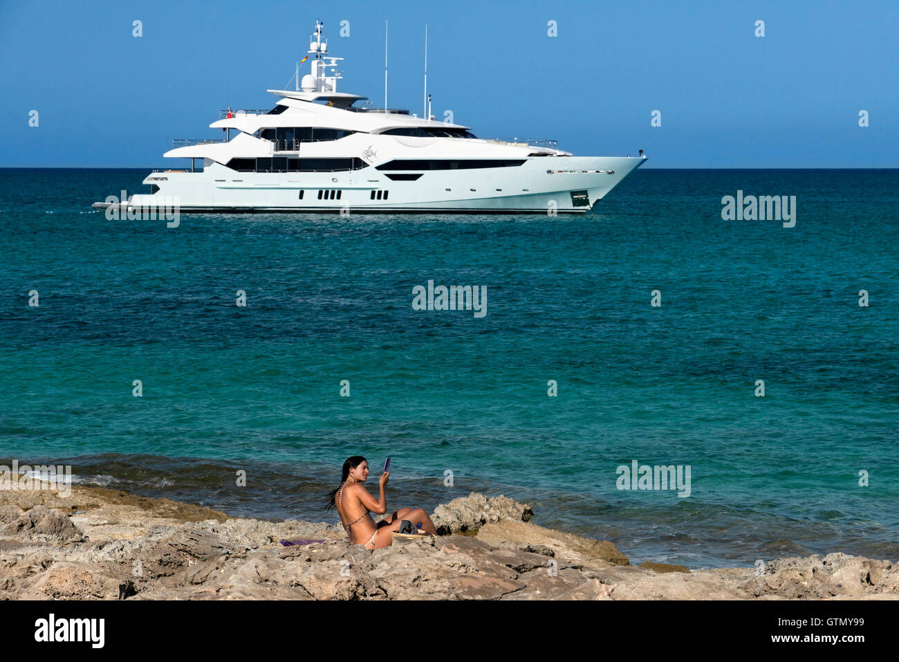 Attractive woman combing. Es Pujols beach, Formentera. Luxury yacht in turquoise water in Es Pujols beach Formentera mediterrane Stock Photo