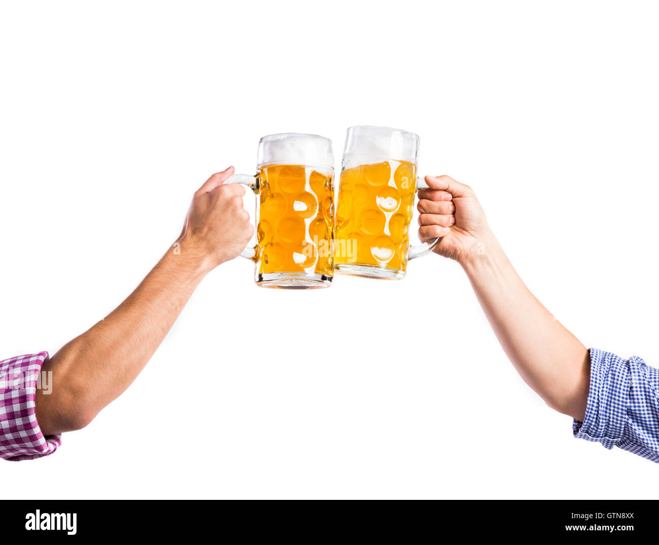 Two unrecognizable men clinking with beer mugs, studio shot Stock Photo