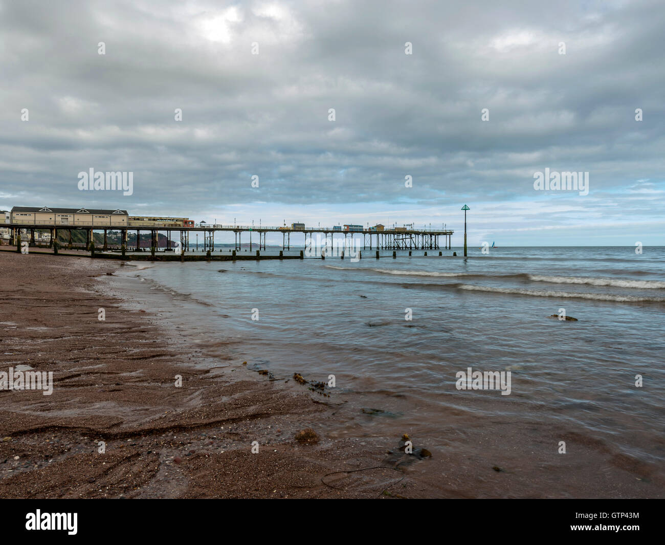 Landscape depicting the seashore along Teignmouth beach at Teignmouth, with views of the Grand Pier. Stock Photo