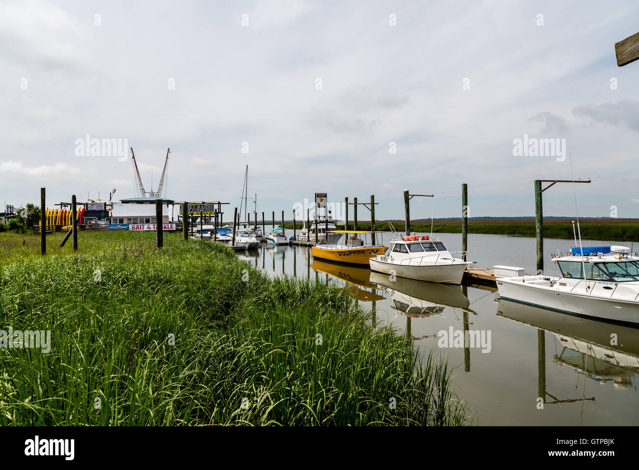 Shrimp, Fishing and tour boats on a river by a salt water marsh between