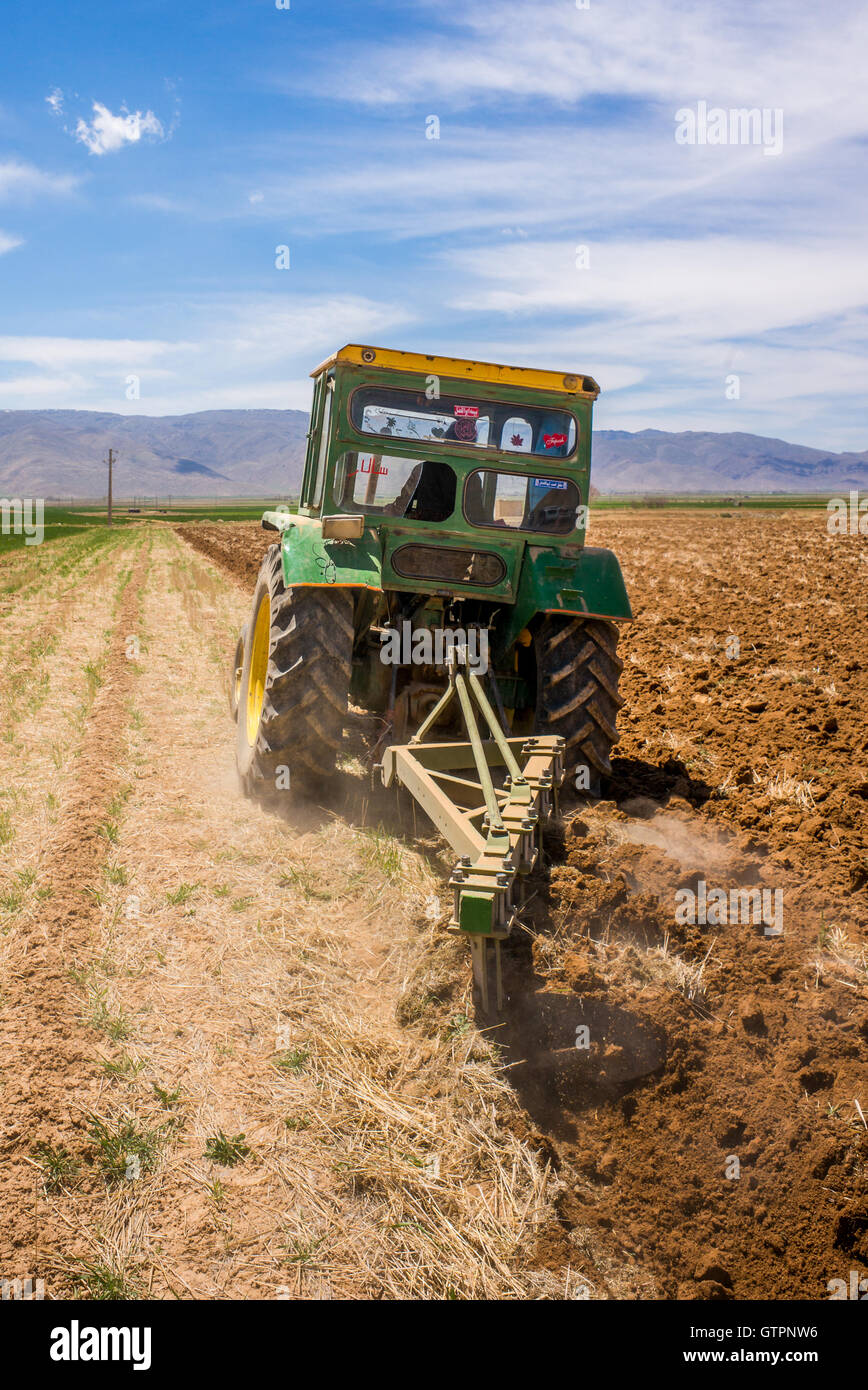 Farmer discing his fields in rural Fars Province, Iran, with John Deere