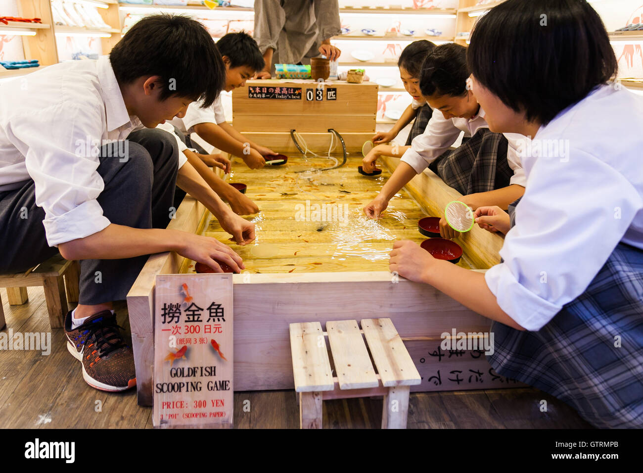 Customers try to catch small kingyo (goldfish) at the Asakusa Kingyo store on September 9, 2016, Tokyo, Japan. Asakusa Kingyo is a goldfish concept store where customers can buy various kinds of traditional Japanese goldfish shaped gifts. The store also challenges customers to play the Goldfish Scooping Game to scoop goldfish or discount coupons. The store opened two months ago, and customers, especially foreigners, who have never been to a Japanese summer festival have the opportunity to enjoy the traditional game. © Rodrigo Reyes Marin/AFLO/Alamy Live News Stock Photo