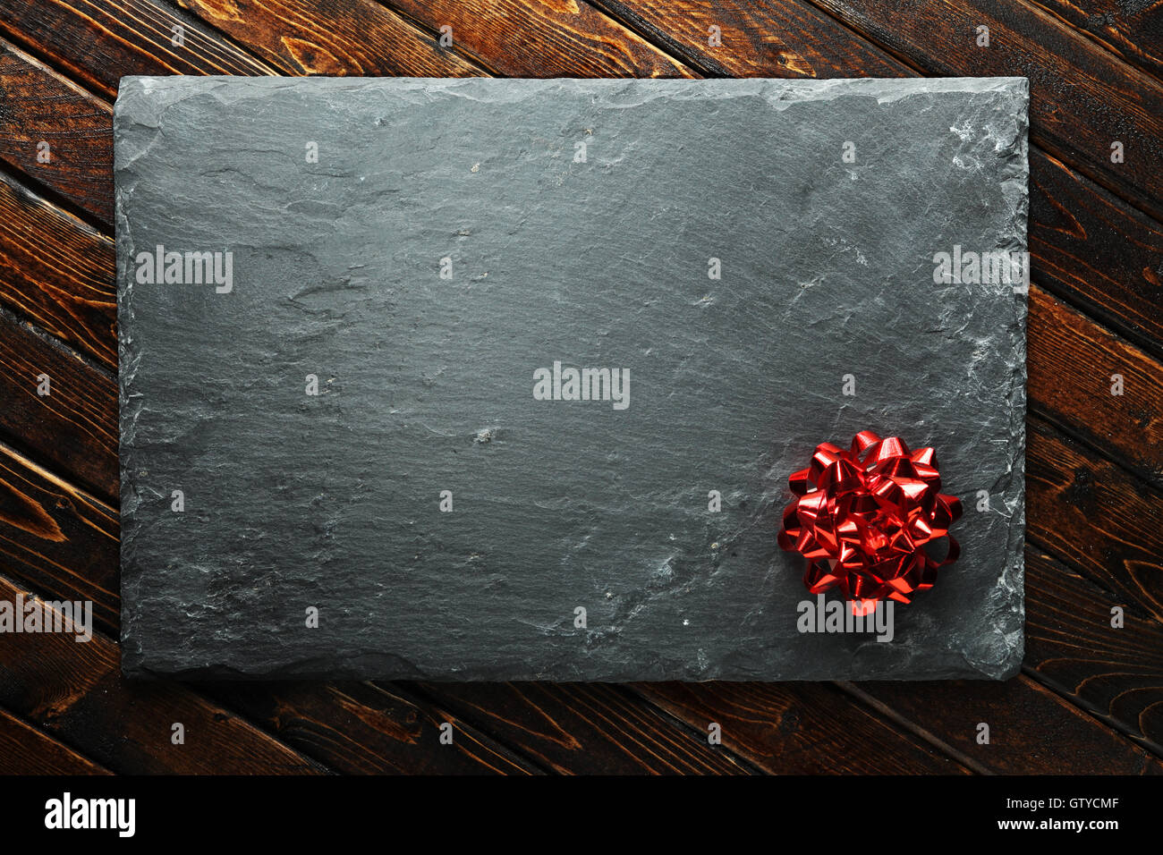 Christmas background with red bow on blank slate Stock Photo