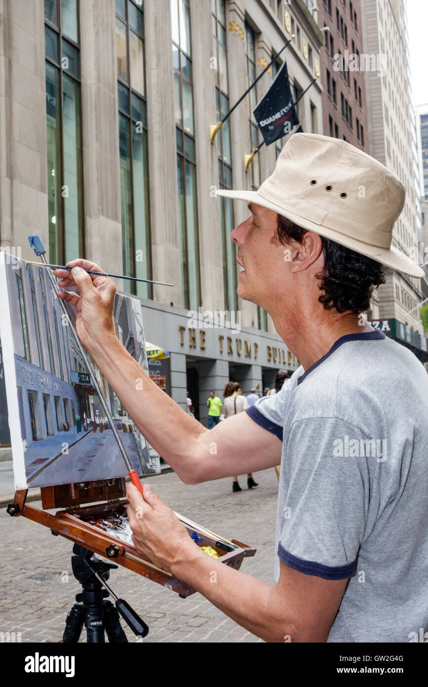 New York City,NY NYC Lower Manhattan,Financial District,Wall Street,Trump building,exterior,adult,adults,man men male,artist,painter,canvas,painting,b Stock Photo