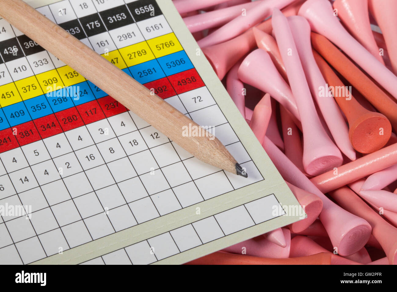 Wooden pencil and golf score card lying on a pink golf tees Stock Photo