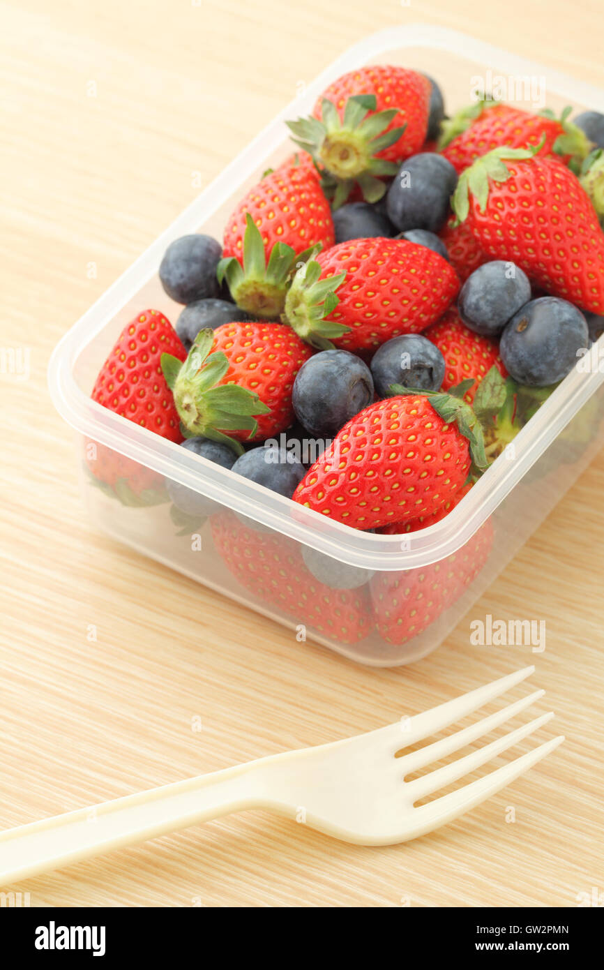 Strawberry and blueberry mix in plastic container Stock Photo