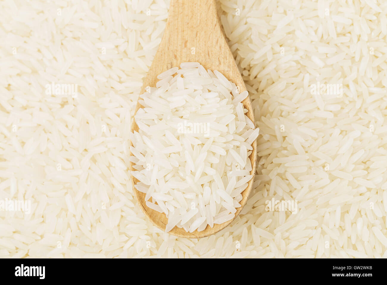 Uncooked rice on spoon Stock Photo Alamy