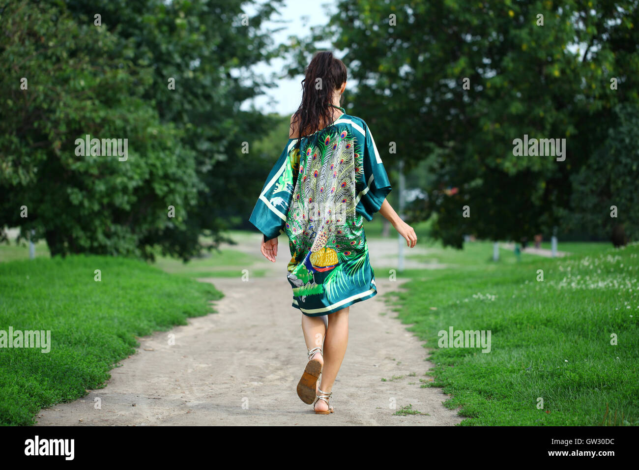 Beautiful young woman walking on the summer park Stock Photo - Alamy
