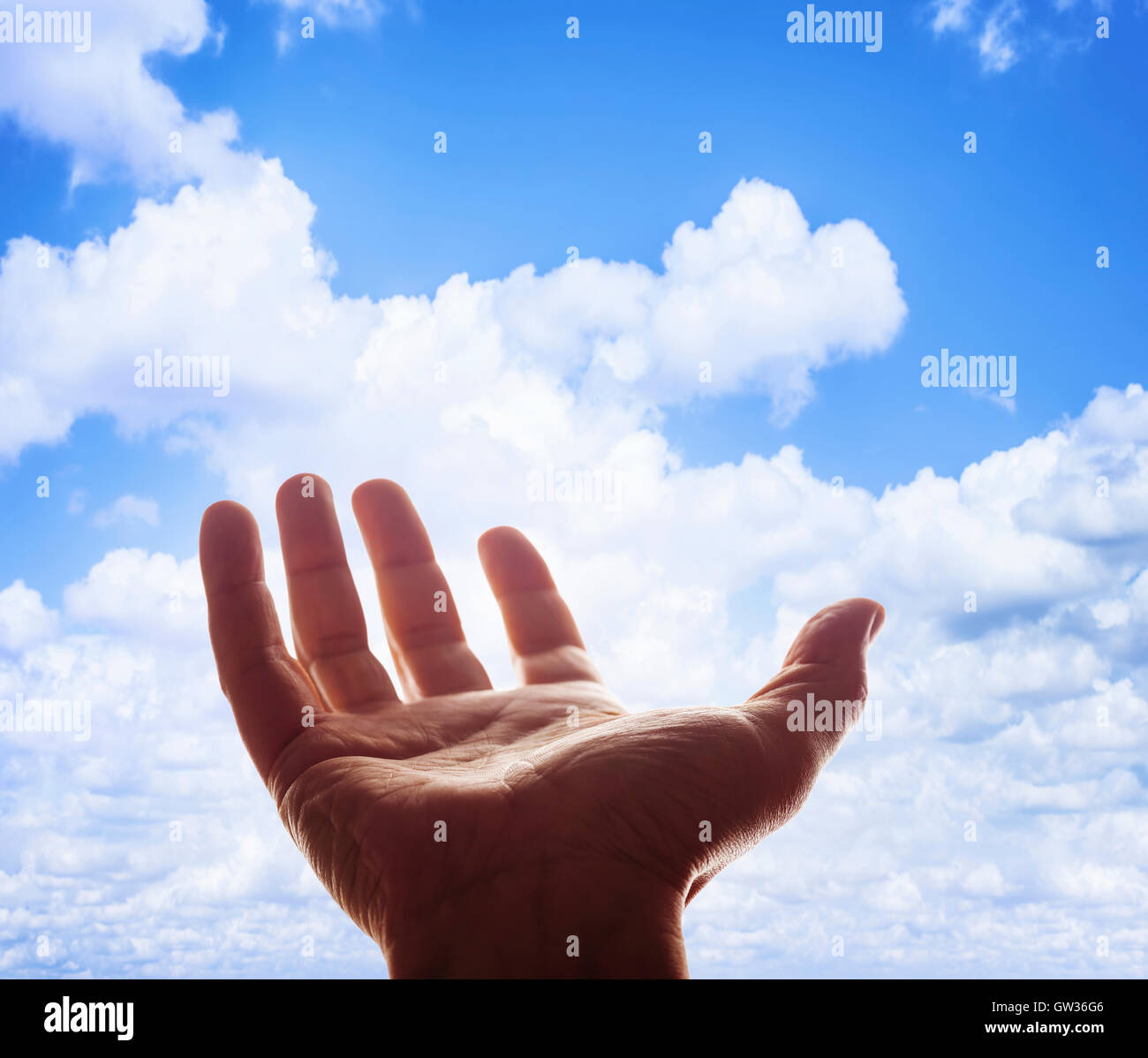 Open hand against blue sky. Stock Photo