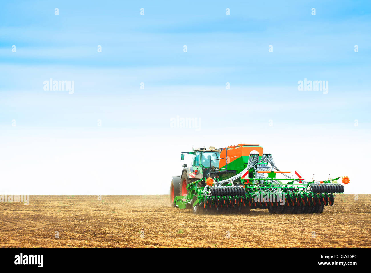 Tractor with a harrow to work the land field Stock Photo - Alamy