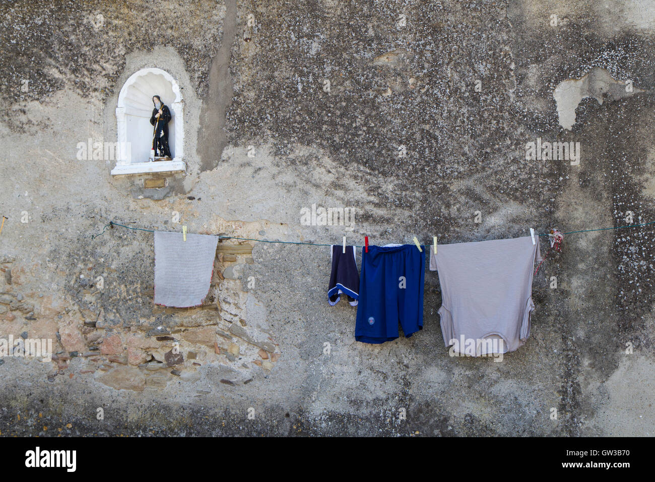 Washing hanging to dry outside a wall with holy Stock Photo