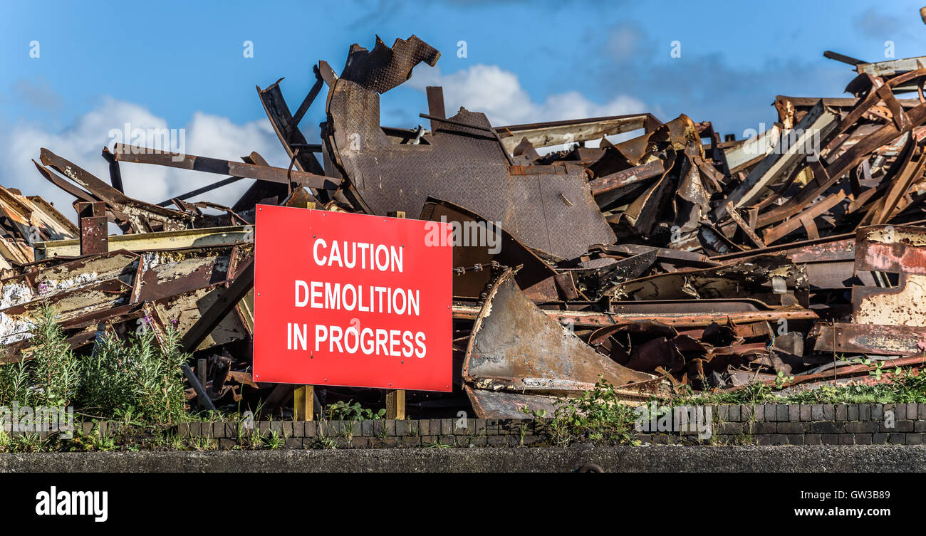 Demolition warning sign with scrap metal structure. Stock Photo