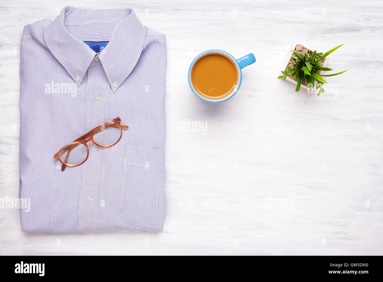 Businessman shirt, cup of coffee and hipster glasses on white wooden background. Business and office concept. Lifestyle. Stock Photo