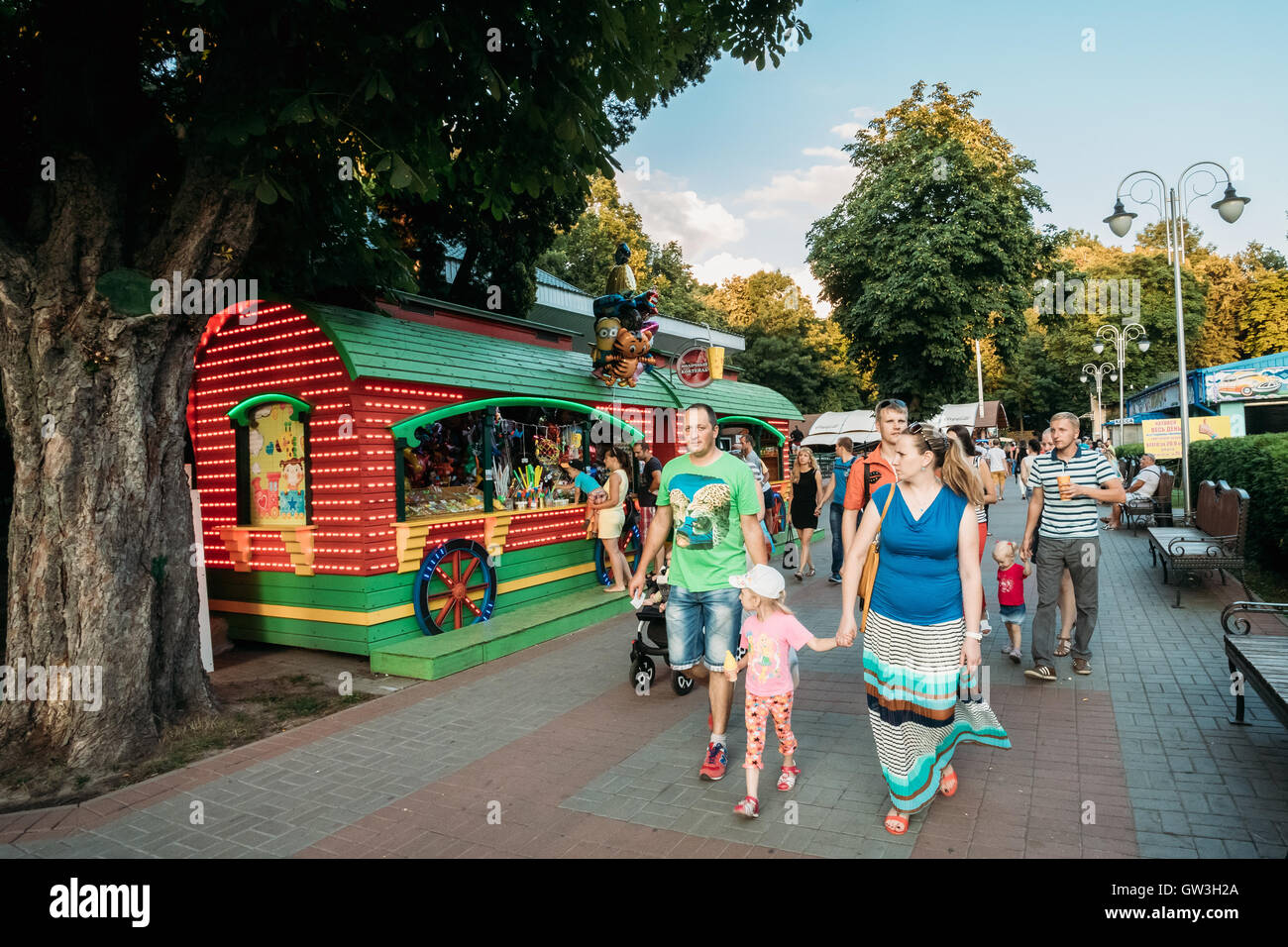 Families With One Children Of Elementary Age Walking On The Footpath In Summer Amusement Park In Gomel Belarus Stock Photo